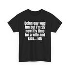 Black t-shirt printed with "Being gay was fun but I'm 25 now it's time for a wife and kids… idk", shown flat from another angle.
