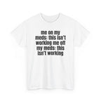 White t-shirt printed with "Me on my meds: this isn't working. Me off my meds: this isn't working", shown flat from another angle.