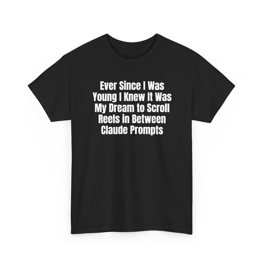Black t-shirt printed with "Ever since i was young i knew it was my dream to scroll reels in between Claude prompts", shown flat from another angle.