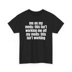 Black t-shirt printed with "Me on my meds: this isn't working. Me off my meds: this isn't working", shown flat from another angle.