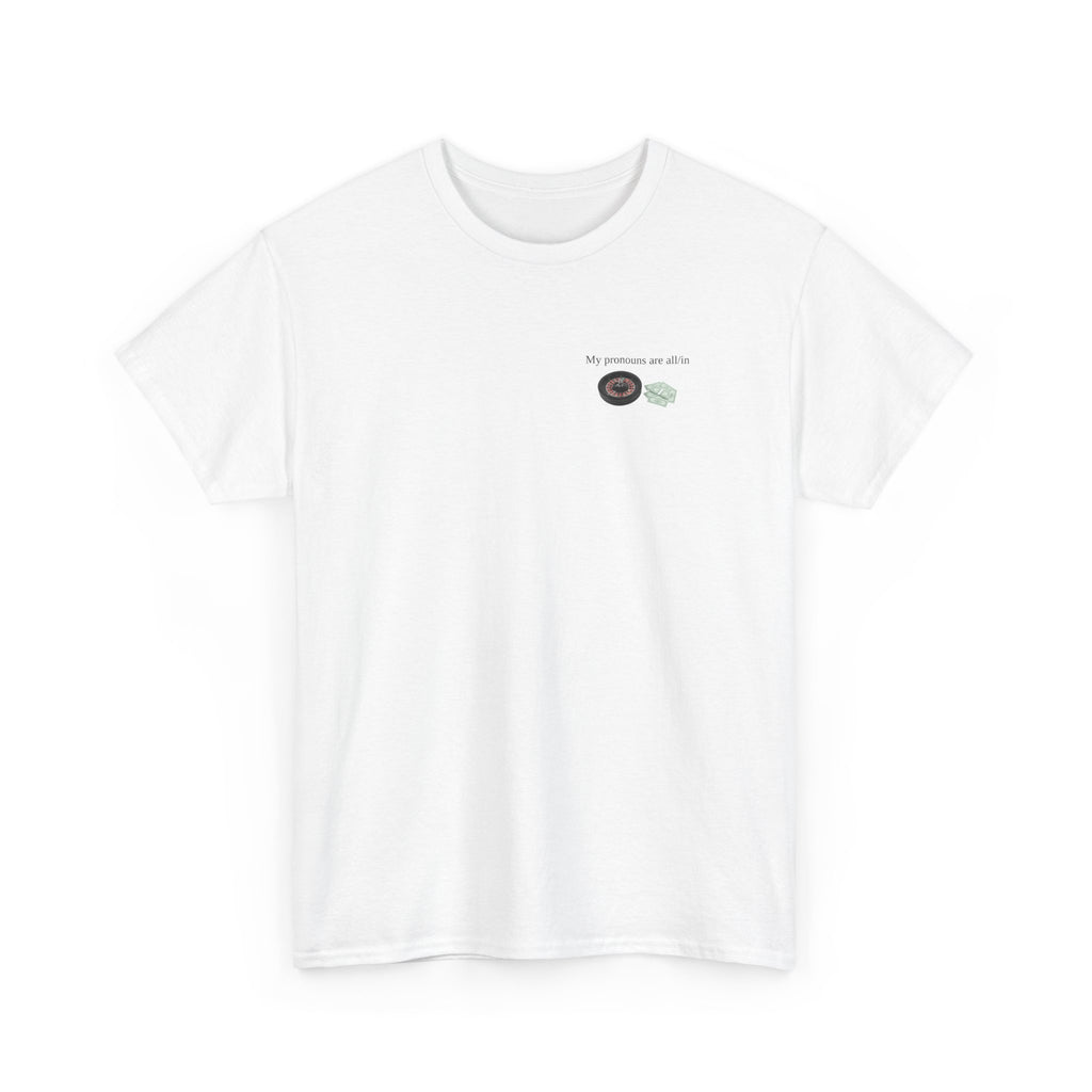 White t-shirt printed with "My pronouns are all/in" in serif type above a roulette wheel and a fanned pile of banknotes, shown flat from another angle.