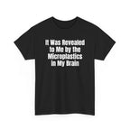 Black t-shirt printed with "It was revealed to me by the microplastics in my brain", shown flat from another angle.