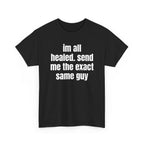 Black t-shirt printed with "im all healed. send me the exact same guy", shown flat from another angle.