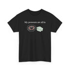 Black t-shirt printed with "My pronouns are all/in" in serif type above a roulette wheel and a fanned pile of banknotes, shown flat from another angle.