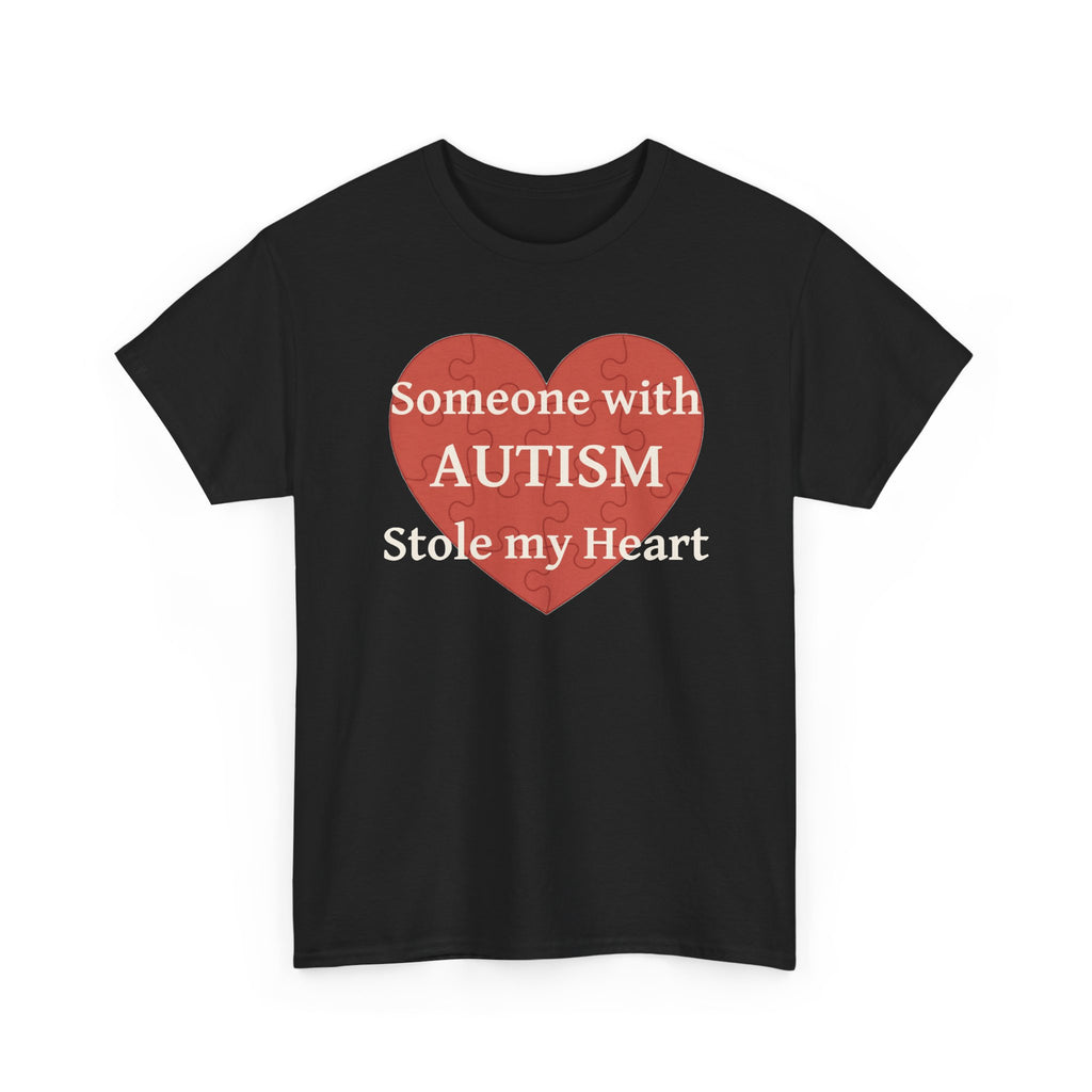 Black t-shirt printed with a large salmon-red heart made of jigsaw puzzle pieces, lettered across it "Someone with AUTISM Stole my Heart", shown flat from another angle.