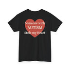 Black t-shirt, back printed printed with a large salmon-red heart made of jigsaw puzzle pieces, lettered across it "Someone with AUTISM Stole my Heart", shown from another angle.