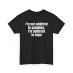 Black t-shirt printed with "I'm not addicted to gambling, I'm addicted to hope", shown flat from another angle.
