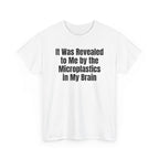 White t-shirt printed with "It was revealed to me by the microplastics in my brain", shown flat from another angle.