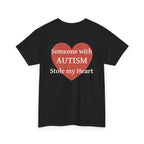 Black t-shirt, back printed printed with a large salmon-red heart made of jigsaw puzzle pieces, lettered across it "Someone with AUTISM Stole my Heart", shown from another angle.